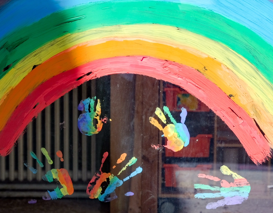 Regenbögen und Kinderhandabdrücke Bunter Regenbogen mit gemalten Handabdrücken – Die Glückskette schenkt Kindern in Not Hoffnung.