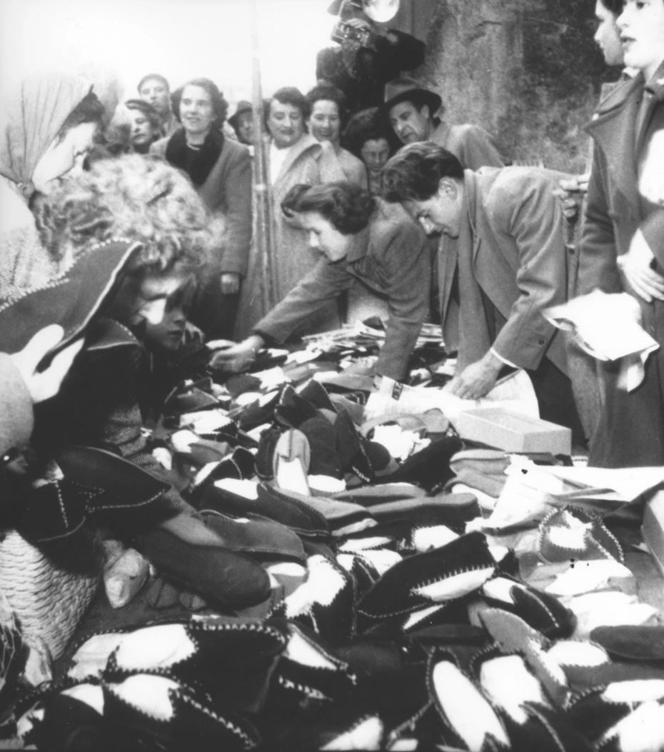 Freiwillige stellen aus alten Filzhüten Hausschuhe her - einfallsreiche humanitäre Hilfe der Glückskette im Jahr 1948.