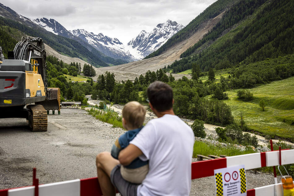 Bergsturz in Blatten 2025 Un père et son enfant regardent la zone du glissement de terrain à Blatten - donner de l'espoir en aidant et en soutenant sur place.