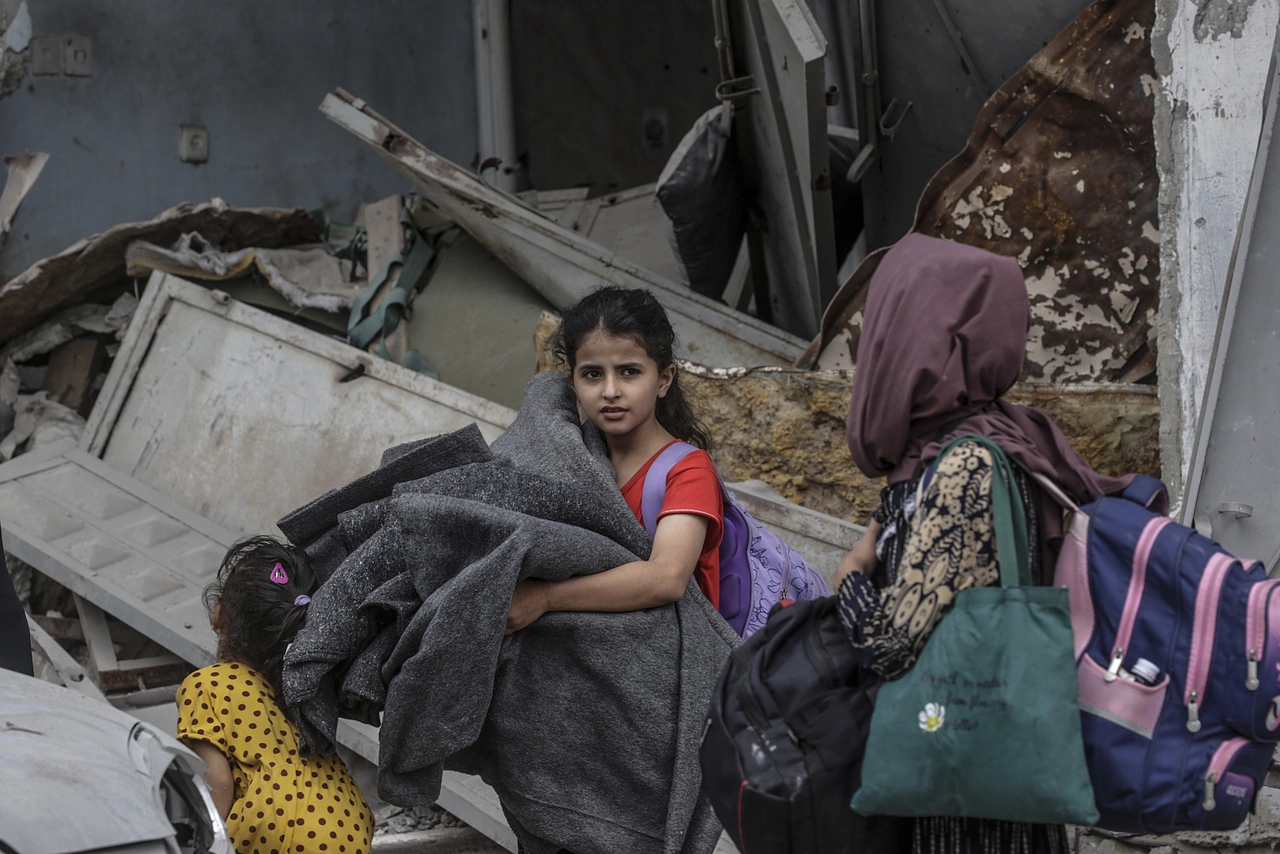 Ein Mädchen in Gaza hat ihre Sachen gepackt – auf der Flucht vor Gewalt und Zerstörung, dringend auf Hilfe angewiesen.