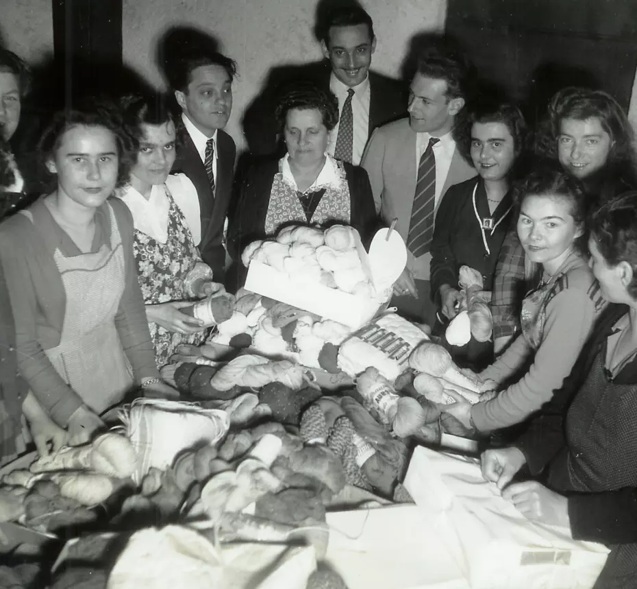 Menschen sammeln Garn an einem Spendentisch - 1951 Aktion zur Unterstützung von Menschen, die unter extremer Kälte leiden.