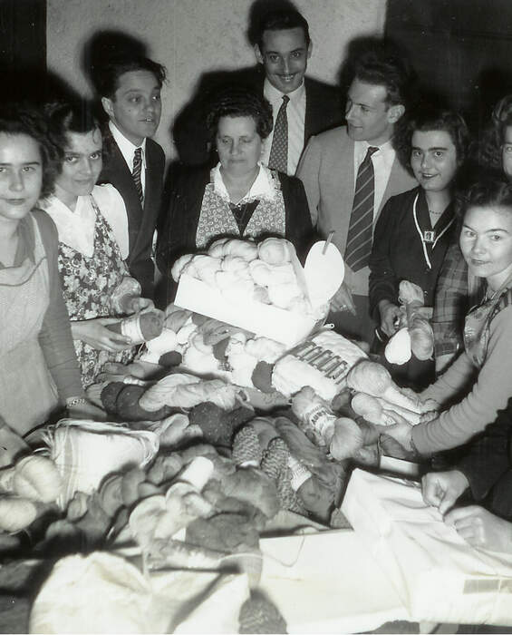 Stricken von Garn für kältegeschädigte Familien im Jahr 1951 Menschen sammeln Garn an einem Spendentisch - 1951 Aktion zur Unterstützung von Menschen, die unter extremer Kälte leiden.
