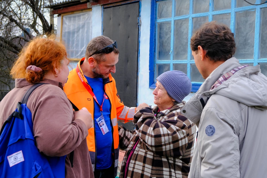 Eine ältere Frau wird von Medair-Mitarbeitenden vor ihrem Haus beraten – Bargeldhilfe zur Deckung lebenswichtiger Bedürfnisse wie Heizung, Kleidung, medizinische Versorgung oder Transport.