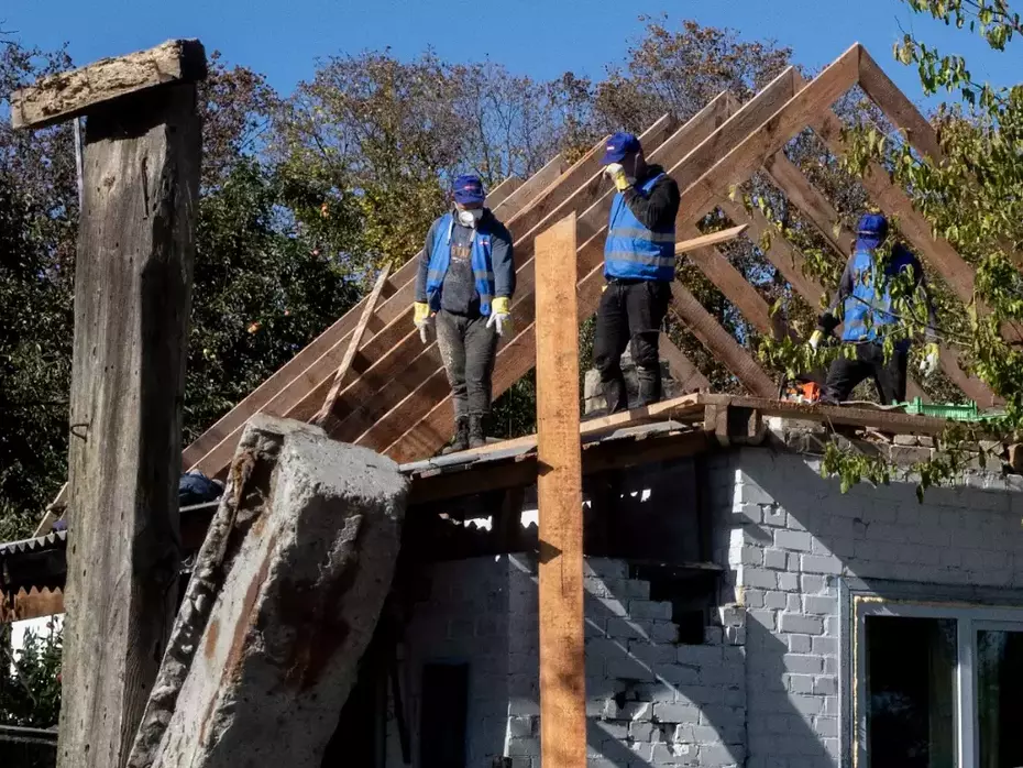 Helfer reparieren den Dachstuhl eines beschädigten Hauses – Wiederaufbauhilfe ermöglicht betroffenen Familien das Weiterleben in ihren eigenen vier Wänden.
