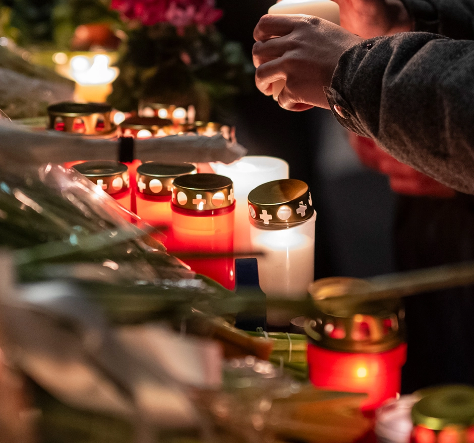 Person zündet Kerzen für einen Traueraltar an